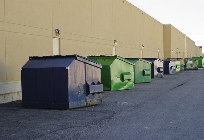 a fleet of red and blue construction dumpsters available for use in Carson, CA